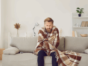 cold homeowner wrapped in blanket because heater won't turn on